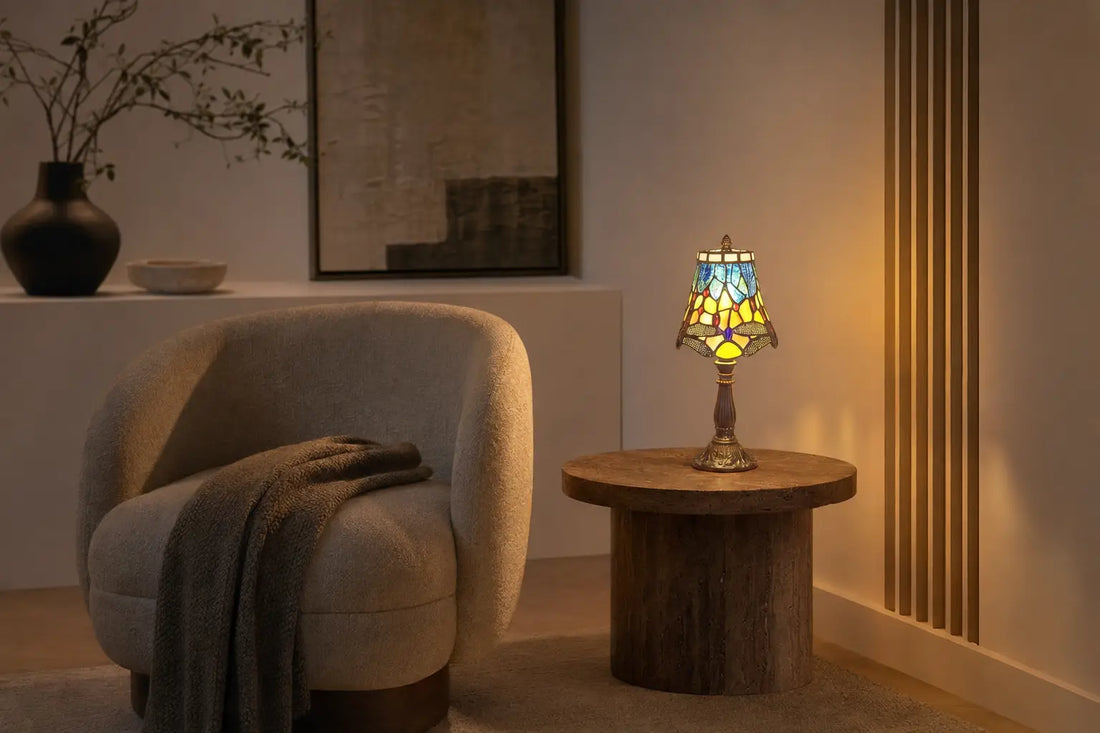 Brandende Tiffany tafellamp 7003 met kleurrijk libellenmotief op een bijzettafel in een warme, moderne leeshoek | RORUVERA