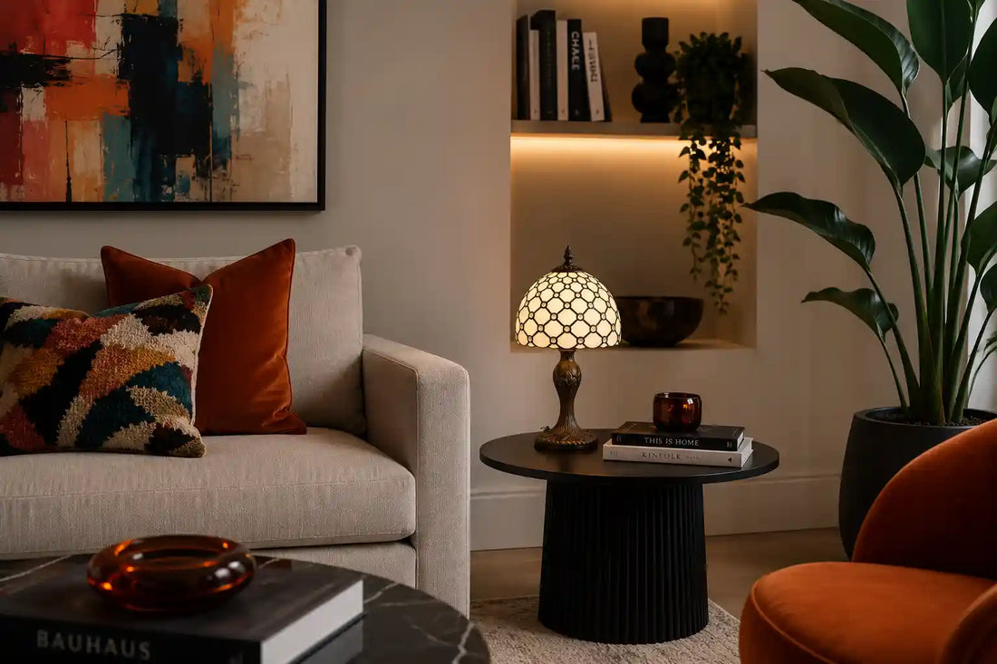 Tiffany tafellamp met crème glas-in-lood kap op een houten hoektafel in een klassieke woonkamer met leren fauteuil en sierlijke woonaccessoires | RORUVERA