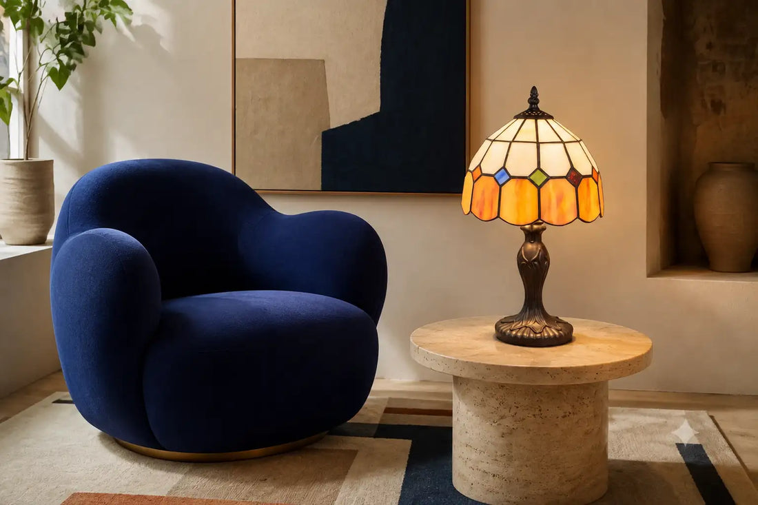 Brandende Tiffany tafellamp 7010 op een travertinen tafel naast een blauwe designfauteuil en abstracte kunst | RORUVERA