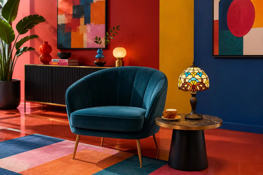 Tiffany tafellamp met kleurrijk glas-in-lood op moderne bijzettafel naast blauwe fluwelen fauteuil in uitgesproken kleurrijk interieur | RORUVERA