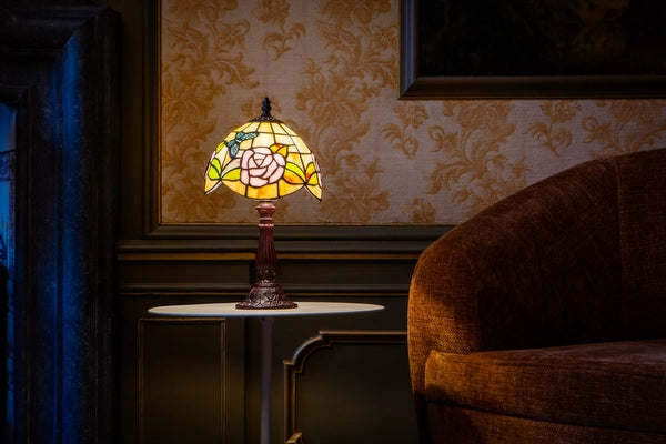 7013 - Tiffany tafellamp met rozenmotief op een ronde witte bijzettafel naast een fauteuil in een klassiek interieur | RORUVERA