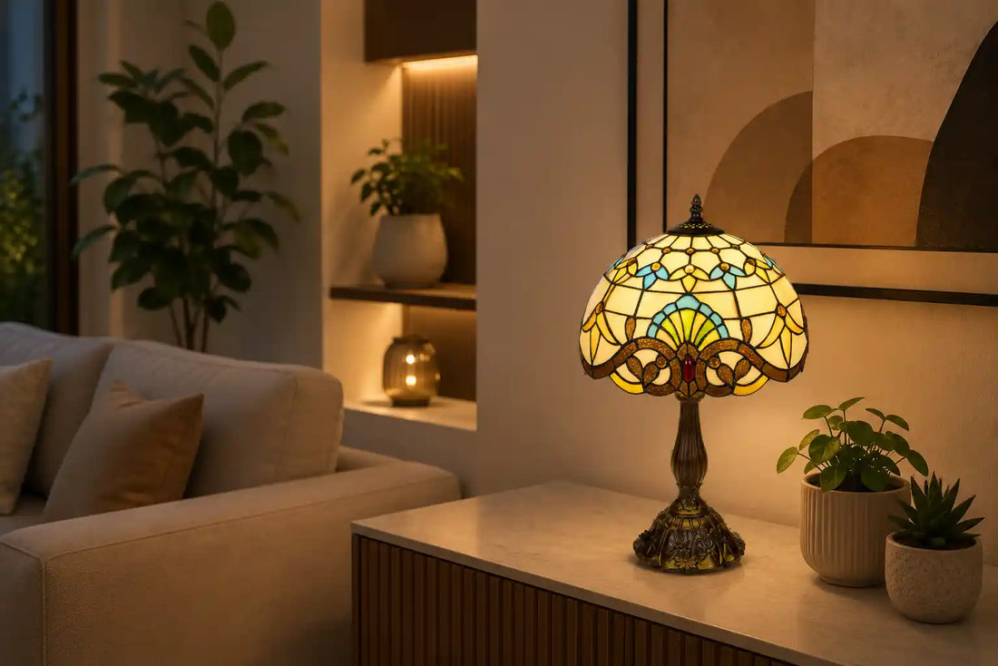 Tiffany tafellamp met crème glas-in-lood, turquoise en amberkleurige accenten op een modern dressoir in een warme woonkamer met lichte bank, abstracte kunst en kleine groene planten | RORUVERA