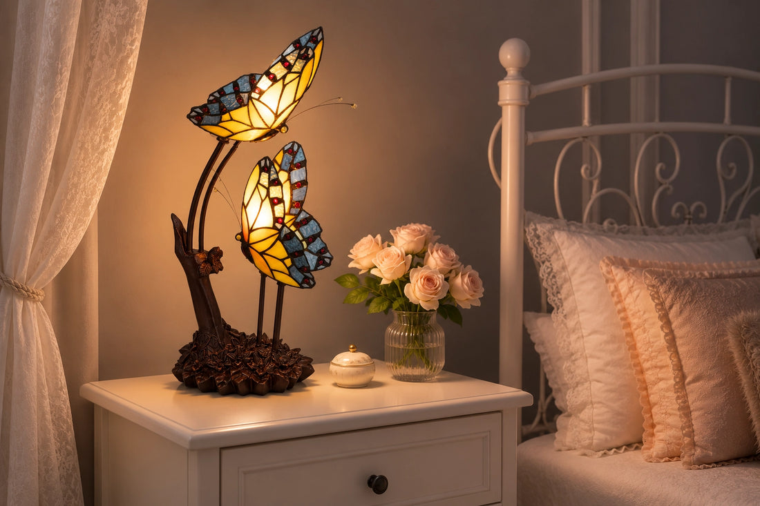 Tiffany dubbele vlinderlamp 7054 in geel, amber en blauwgrijs op een wit nachtkastje naast het bed | RORUVERA