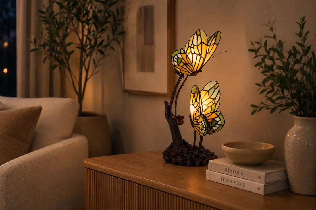 Tiffany dubbele vlinderlamp 7055 in amber, groen en crème op een houten sidetable met planten | RORUVERA