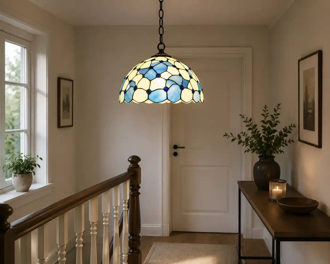 7404 - Tiffany hanglamp met blauwe bloemaccenten en crème glas boven een lichte overloop met houten balustrade | RORUVERA