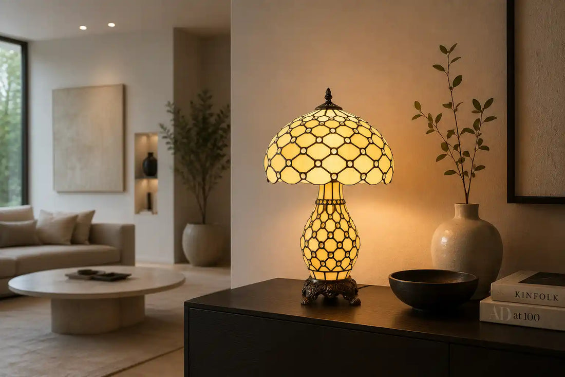 Crème Tiffany tafellamp met verlichte voet en honingraatpatroon op een donker dressoir in een minimalistische woonkamer | RORUVERA