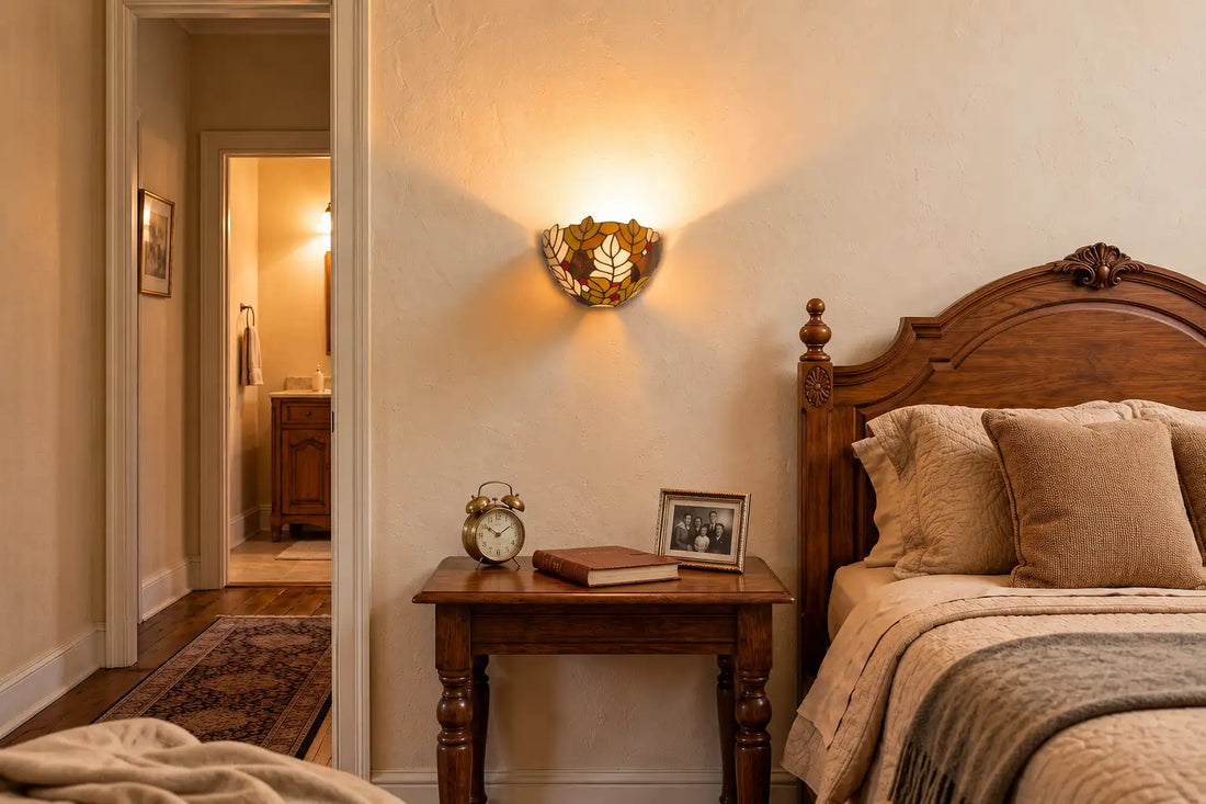 Tiffany wandlamp met bladmotief boven een houten nachtkastje in een sfeervolle landelijke slaapkamer | RORUVERA