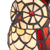 Detail Tiffany uillamp met bronskleurige voet in boomstronkvorm van glas in lood in rood,- en cremetinten