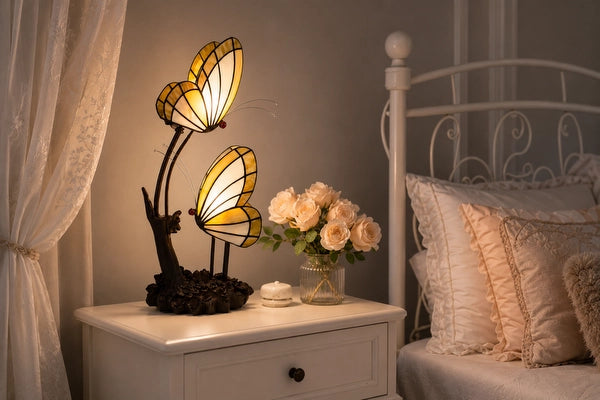Tiffany dubbele vlinderlamp 8102 in crème en amber op een wit nachtkastje naast het bed | RORUVERA