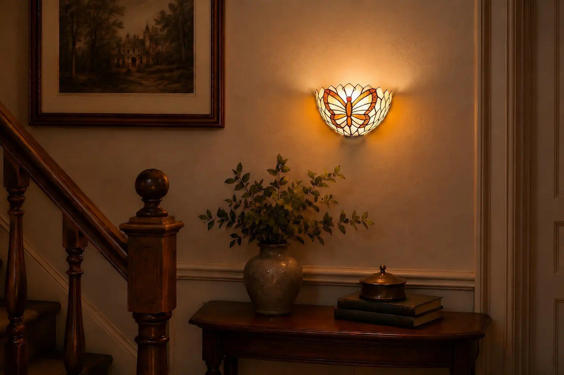 Tiffany wandlamp met vlindermotief aan een lichte wand naast een houten trap in een sfeervolle klassieke hal | RORUVERA